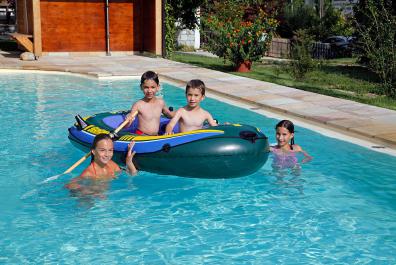 Kinder spielen mit Schlauchboot im Pool